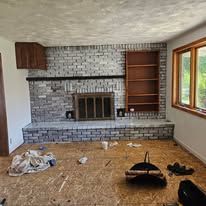 Brick fireplace with a varied white limewash finish during renovation